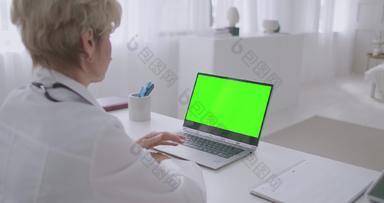 岁的女医生工作远程在线咨询绿色屏幕移动PC浓度关键技术远程医疗