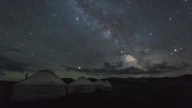 时间孩子乳白色的移动蒙古包营晚上布满星星的天空云