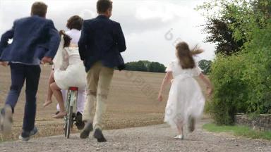 孩子们运行新婚夫妇骑自行车污垢路丁顿威尔特郡曼联王国