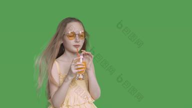 少年女孩喝橙色汁稻草玻璃透明的绿色背景年轻的女孩享受新鲜的橙色鸡尾酒绿色背景α通道键控绿色屏幕