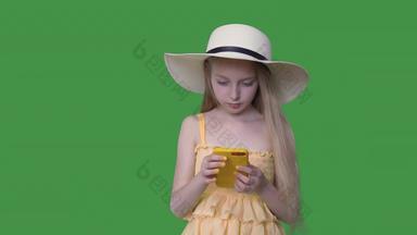 年轻的女孩他黄色的衣服移动电话透明的绿色背景夏天女孩头发挥舞着风浏览智能手机绿色背景α通道键控绿色屏幕