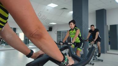 女人旋转自行车骑自行车类<strong>健身</strong>房俱乐部集团<strong>健身</strong>人培训自行车锻炼自行车培训<strong>健身</strong>类有氧运动锻炼静态自行车