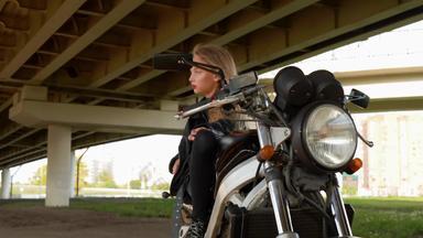 有吸引力的女孩摩托衣服坐着黑色的摩托车年轻的骑摩托车的人女孩皮革夹克摆姿势摩托车车路景观