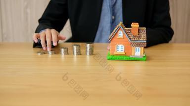 手爬硬币堆栈持有房子模型储蓄钱购买首页抵押贷款贷款财产梯真正的房地产投资