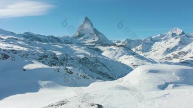 马特洪峰山站徒步旅行者冬天一天瑞士阿尔卑斯山脉瑞士低水平飞行男人。空中视图无人机苍蝇向后
