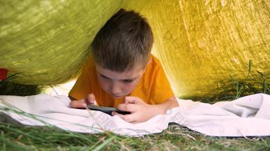孩子阅读电子书移动户外孩子小工具公园花园<strong>男孩</strong>帽<strong>玩游戏</strong>智能手机学习教育在线学龄前儿童花时间新鲜的空气儿科心理学