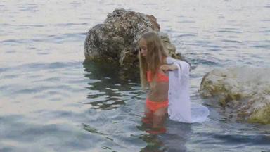 年轻的女孩泳衣束腰外衣走石头<strong>海水</strong>夏天海滩少年女孩<strong>海水</strong>岩石海滩夏天假期