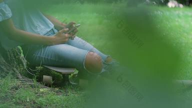 有<strong>选择性</strong>的焦点斯洛女人坐着滑板树智能手机哈克尼伦敦英格兰