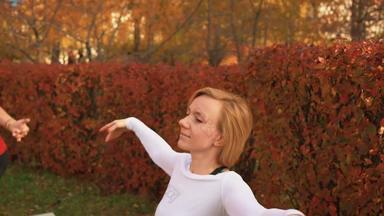 健身女人跳舞芭蕾舞类秋天公园体育运动女人培训跳舞锻炼秋天公园慢运动女人练习跳舞户外