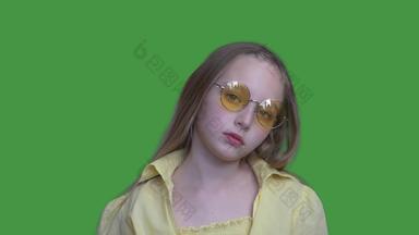 年轻的女孩少年黄色的眼镜衣服相机绿色背景女孩摆姿势前面相机浓度关键屏幕α通道键控绿色屏幕