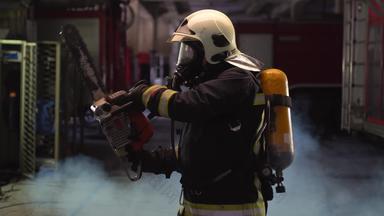 消防队员肖像穿完整的设备氧气面具权力液压切割工具烟火卡车背景