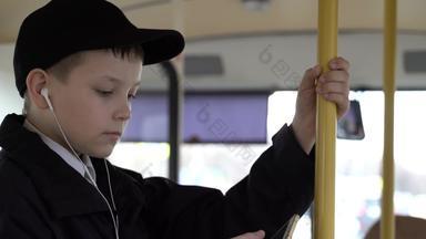 特写镜头拍摄年轻的男孩旅行公共汽车城市智能手机听音乐