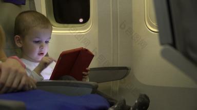 男孩年玩平板电脑应用程序坐飞机座位