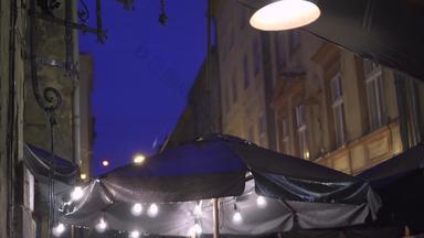 户外街咖啡馆晚上重雨雨滴下降树冠灯笼挂风重倾盆大雨雨倒街户外咖啡馆欧洲小镇