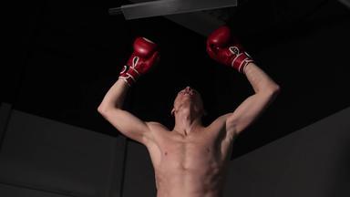 男性拳击手裸体躯干提高手红色的手套胜利冠军战斗机手提高了拳击环享受成功的竞争