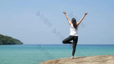 女人站腿练习瑜伽岩石海一边夏天假期有吸引力的年轻的亚洲女人站瑜伽<strong>构成</strong>