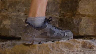 登山者腿徒步旅行靴子攀爬岩石山旅行男性脚徒步旅行鞋子攀爬悬崖徒步旅行旅游旅行概念