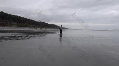 太平洋海岸摄影师走黑色的火山沙子宽海滩低潮奥运国家公园美国华盛顿