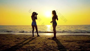 摄影师青少年采取照片女模型海滩日落浪漫的照片会话