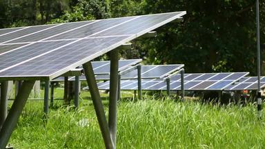 太阳能面板草阳光明媚的一天行替代权力植物草坪上生产生态能源保护环境绿色概念现代技术创新