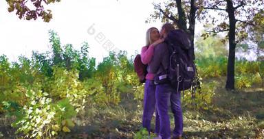 年轻的夫妇游客秋天森林阳光明媚的下午金发女郎女孩轻轻拥抱的男朋友高加索人年轻的男人。吻