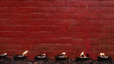 燃烧灯红色的砖墙行燃烧纪念灯背景明亮的红色的墙寺庙