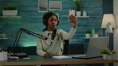 垂直视频非洲女人智能手机采取自拍播客
