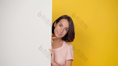 漂亮的年轻的女孩窥视角落里相机看家庭微笑年轻的女孩光粉红色的t恤角落里孤立的黄色的背景