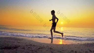 特写镜头年轻的男孩运行慢跑海海滩日落替身拍摄