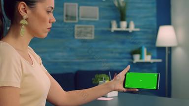 高加索人女持有孤立的智能<strong>手机模拟</strong>绿色屏幕