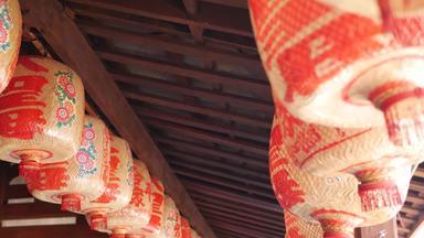 纸灯笼破旧的建筑红色的纸灯笼挂天花板饱经风霜的混凝土寺庙建筑阳光明媚的一天东方国家传统的装饰