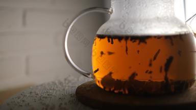 特写镜头酝酿黑色的茶玻璃茶壶茶叶子玩光上升秋天金颜色茶有<strong>选择性</strong>的焦点模糊砖白色背景
