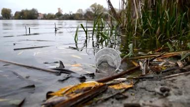 塑料污染水的身体塑料杯鸡尾酒慢慢地漂流水反映表面水生态问题环境污染