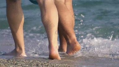 同性恋夫妇走光着脚桑迪海海岸海滩