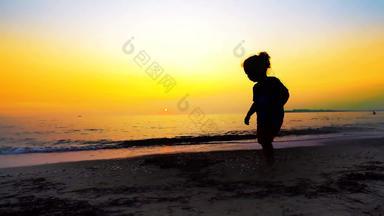 轮廓年轻的男孩走空海滩夏天日落背景电影替身拍摄