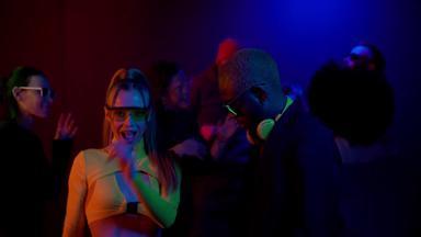 跨种族夫妇跳舞俱乐部霓虹灯灯快乐夫妇迪斯科休息室酒吧计数器跳舞黑色的背景霓虹灯颜色人跳舞年轻的人有趣的俱乐部