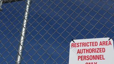 限制区域授权人员标志美国红色的信警告金属栅栏曼联州边境象征非法侵入请注意意味着<strong>违反</strong>者起诉法律