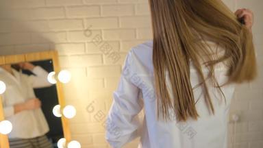 女孩库姆斯长光滑的金头发工作室沙龙前面镜子头发刷健康的光滑的头发女孩特写镜头头发梳子白色衬衫