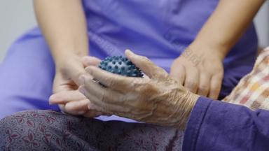 上了年纪的女人橡胶球锻炼手指棕榈手脚肌肉