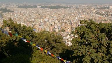 挥舞着祈祷旗帜城市景观视图挥舞着五彩缤纷的祈祷旗帜字符串城市景观加德满都谷斯瓦扬布纳特佛塔猴子寺庙尼泊尔