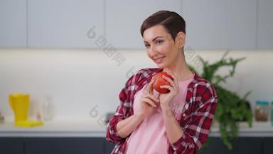 温柔的家庭主妇闻新鲜的苹果持有手穿格子衬衫短发型烹饪苹果馅饼站厨房健康的食物首页fhd镜头