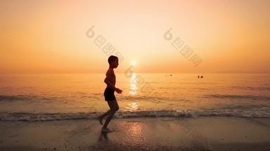 年轻的男孩运行海海滩日落慢运动电影替身拍摄
