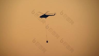 轮廓火战斗直升机携带水桶森林火