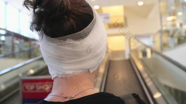 女人头包装医疗绷带移动购物中心自动扶梯持有智能手机
