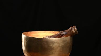 铜唱歌碗旋转轴黑色的背景藏文音乐的仪器冥想替代医学