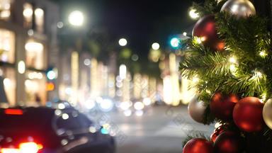特写镜头包厢里装饰户外圣诞节树明亮的红色的球模糊闪闪发光的仙女背景散焦加兰灯散景效果散焦晚上城市街汽车路
