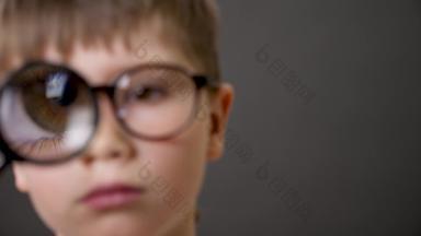 极端的特写镜头眼睛放大放大镜大眼睛男孩关闭孩子放大镜镜头聪明的孩子眼镜盯着相机放大玻璃眼睛孩子探索