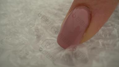 宏拍摄手指持久性有机污染物泡沫点击包装电影塑料包装