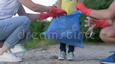 慈善清洁，<strong>带</strong>着<strong>小孩</strong>子戴着橡胶手套的年轻家庭在肮脏的海滩上收集垃圾