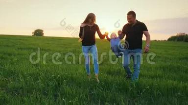 一对<strong>幸福</strong>的父母和一个小儿子正穿过田野走向日落。 有孩子的<strong>幸福</strong>家庭